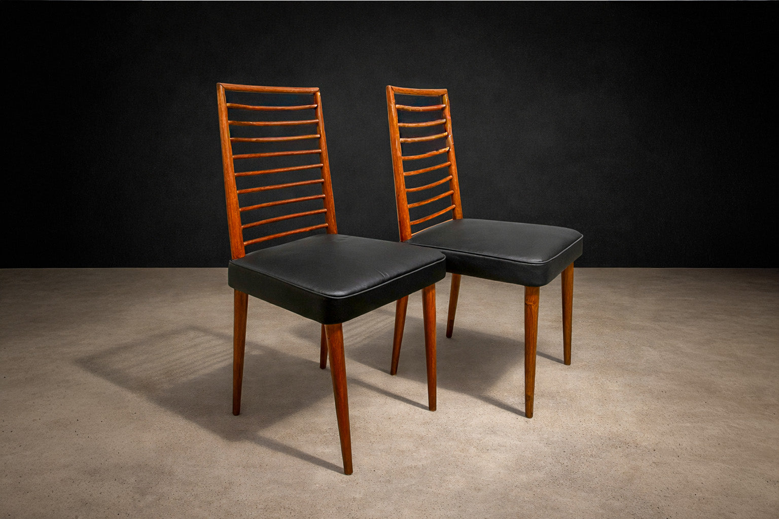 Video of the set of 2 chairs in Hardwood and leather. Shows close ups of the caviuna wood and the black leather seats 